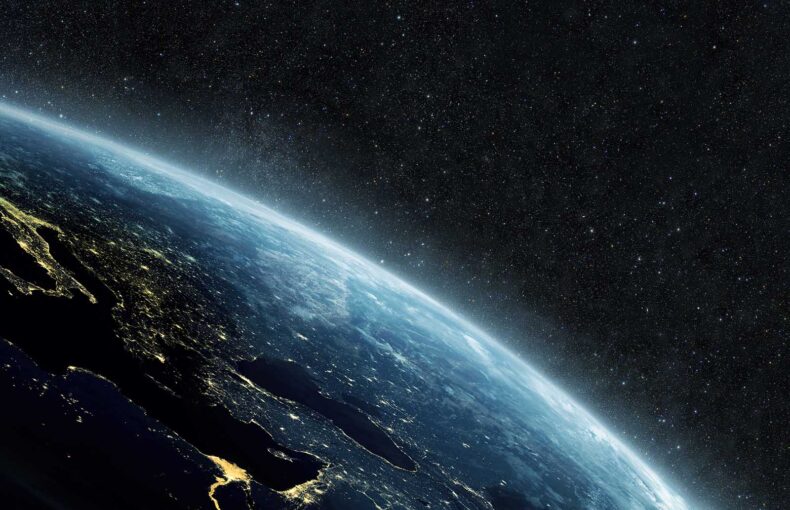 Planet earth with yellow city lights on the starry background in outer space